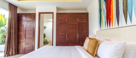 Un dormitorio moderno con una cama grande, armarios de madera y un cuadro abstracto colorido en la pared.