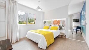 A modern bedroom with a bed, a desk, and a chair. - Sol Mogan Suites (Mogan)