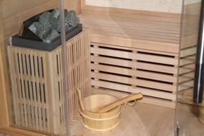 A wooden sauna with a wooden tub and a stone container. - Sol Mogan Suites (Mogan)