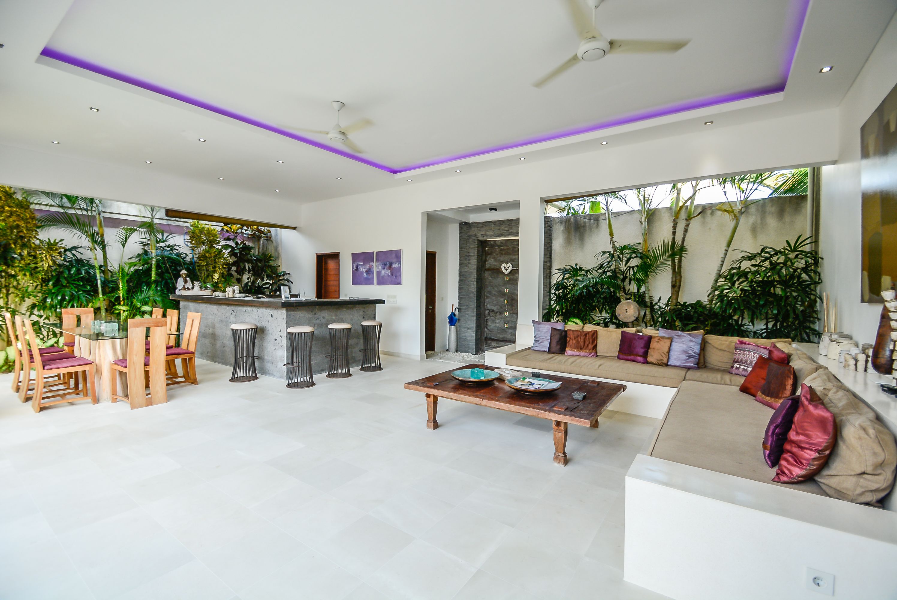 A modern living room with a sofa, coffee table, and dining area with chairs.