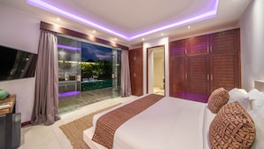 A modern bedroom with a large bed, a glass door leading to a pool, and wooden wardrobes. - Villa Tira (Seminyak)