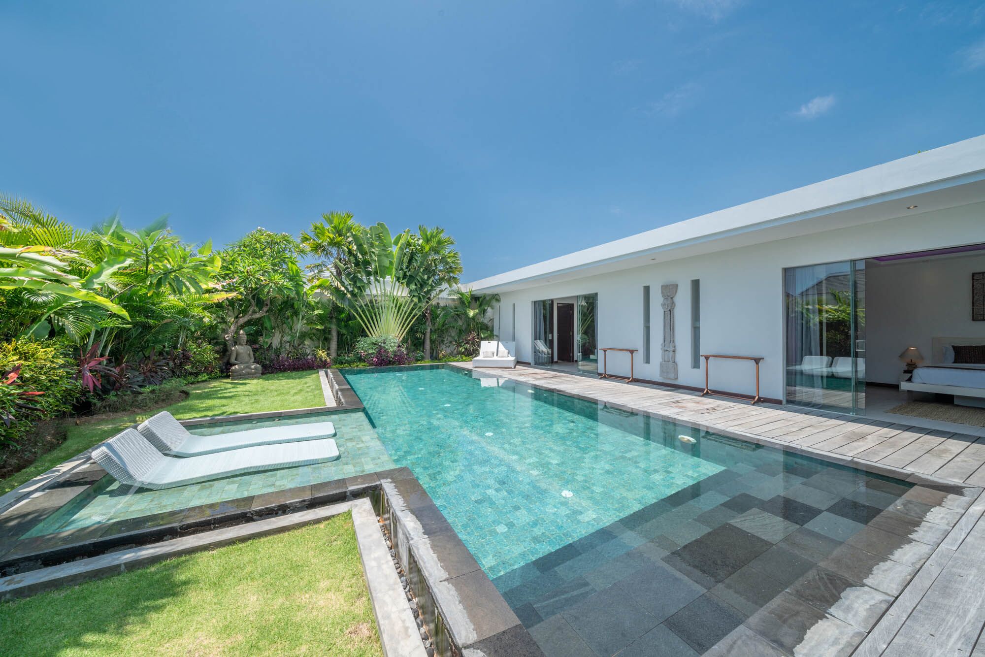 A modern house with a swimming pool, a garden, and a patio area.