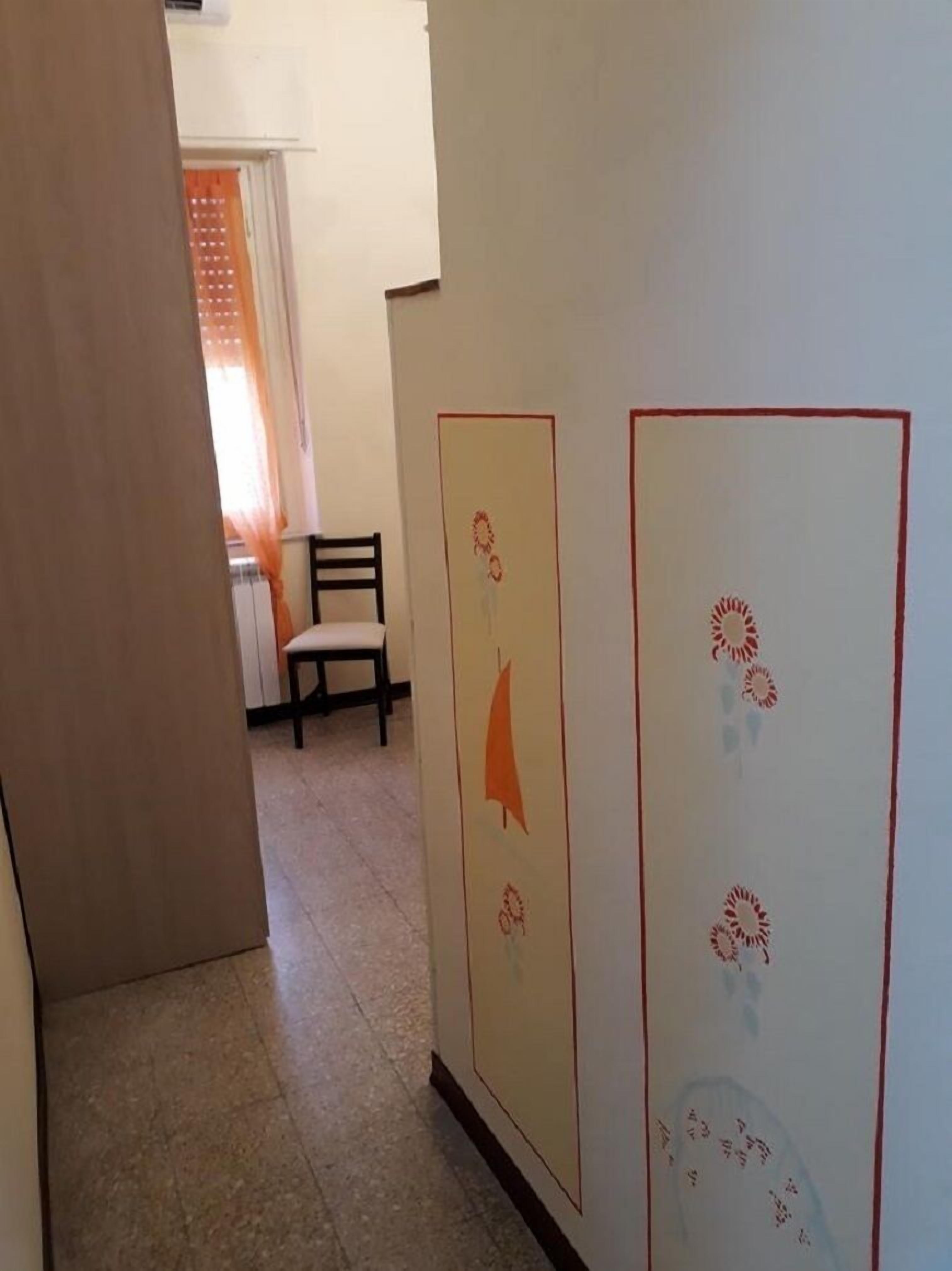 A hallway with a chair and a wall with decorative panels.