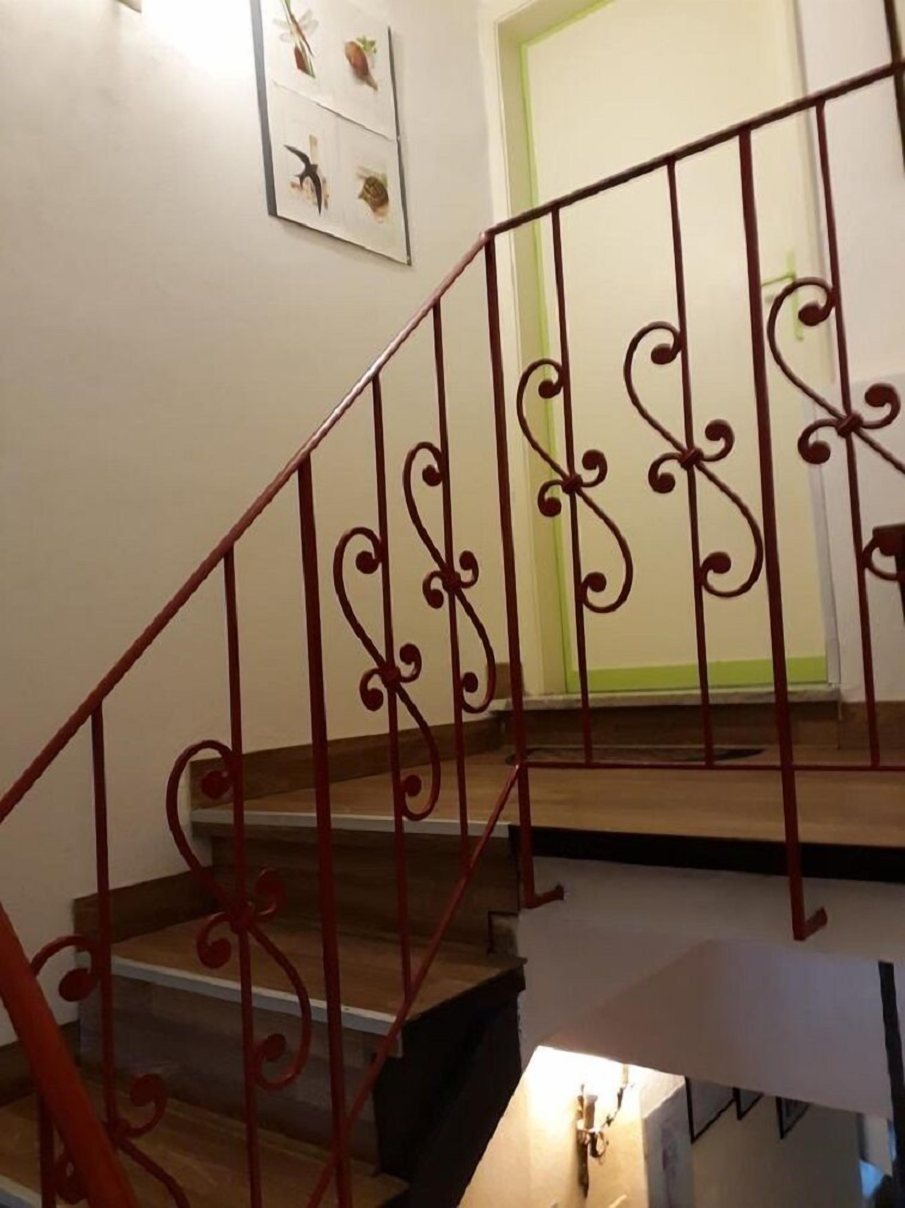 A staircase with ornate red railings and wooden steps.