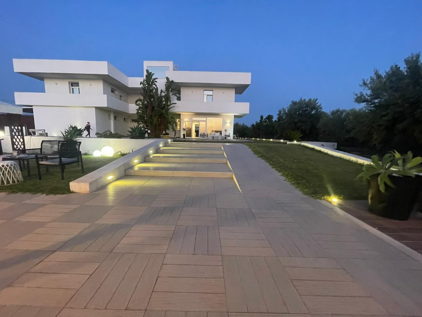 Un bâtiment moderne avec un chemin pavé menant à l’entrée.