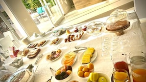 Un buffet de petit-déjeuner proposant une variété de fruits, de viennoiseries et de boissons.