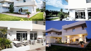 Une maison moderne à deux étages, dotée d’un toit plat, de grandes fenêtres et d’un patio aménagé avec du mobilier d’extérieur.
