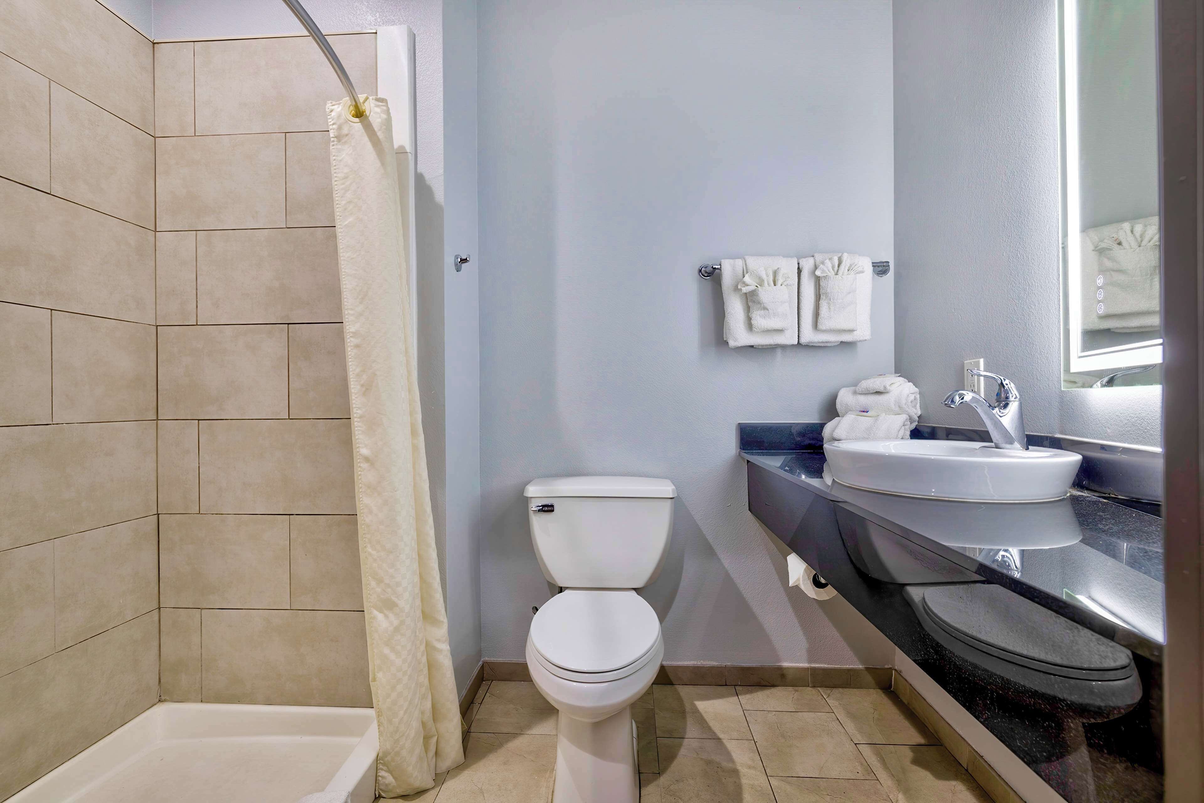 A bathroom with a bathtub, toilet, and sink.