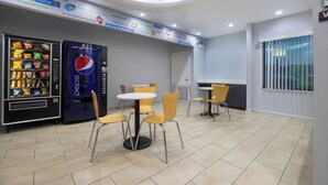 Um café limpo e moderno, com máquinas automáticas, mesas e cadeiras.