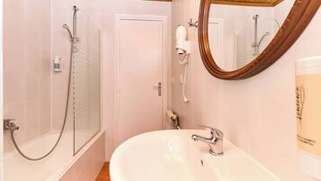 Ein Badezimmer mit Dusche, Waschbecken und Spiegel.