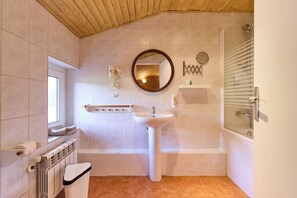 A bathroom with a white sink, mirror, and shower. There is a window and a towel rack. - Hotel Chalet Peretol (Bordes d'Envalira)