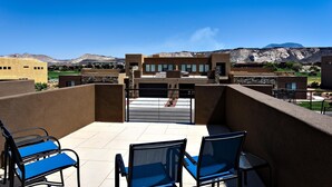 A balcony with blue chairs and a view of mountains. - Desert Cool (St. George)
