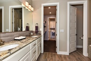 A bathroom with two sinks, a large mirror, and a towel rack. - Retreat On The Green (St. George)