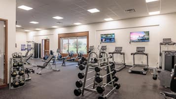 A gym with treadmills, weight machines, and free weights.
