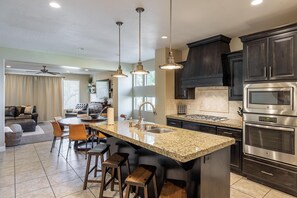 A modern kitchen with granite countertops, stainless steel appliances, and dark cabinetry. - Kickin' It At Karisma (St. George)