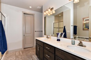 A bathroom with two sinks, a large mirror, and a towel rack.