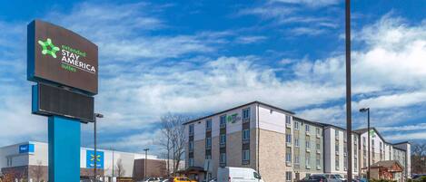 A hotel with a sign for Extended Stay America suites, a Walmart store, and a Holiday Inn Express.