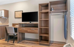 Una cocina moderna con escritorio integrado, una silla y un televisor.