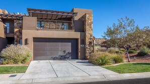 A modern two-story house with a garage, stone accents, and a well-maintained lawn. - 18th Fairway to Heaven (St. George)