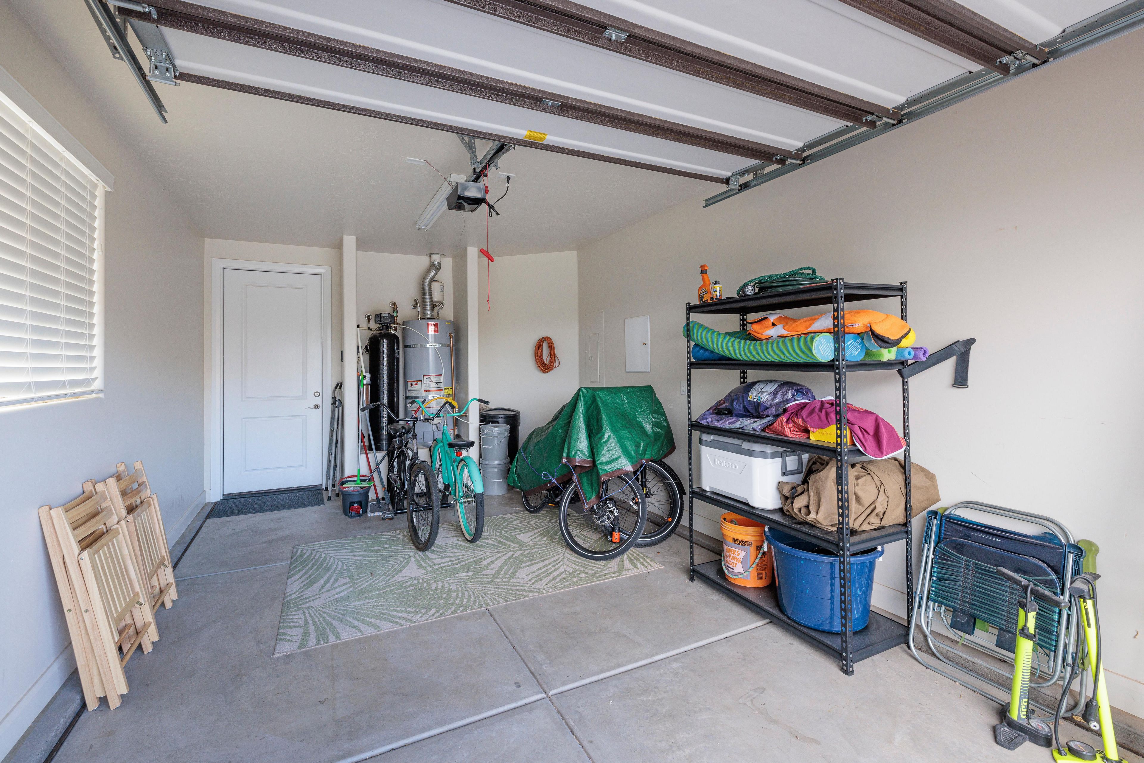A garage with a bicycle, a water heater, and storage shelves.