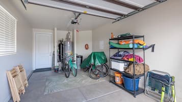A garage with a bicycle, a water heater, and storage shelves.