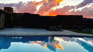 Een zwembad dat een zonsondergang met wolken weerspiegelt.