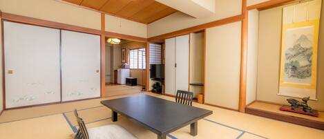 Une pièce de style japonais traditionnel, avec un sol recouvert de tatamis, une table basse et des portes coulissantes.