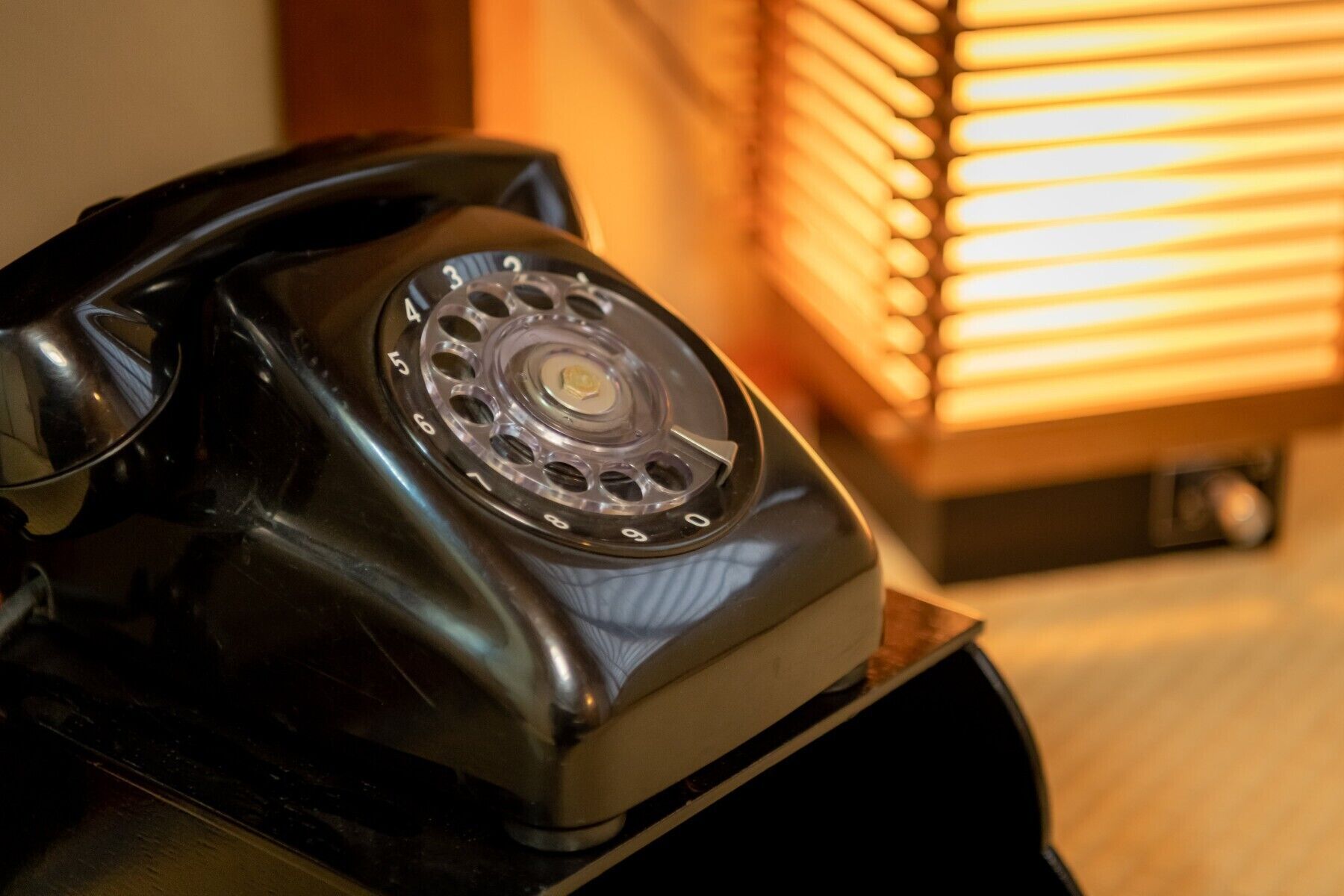 Un téléphone à cadran rotatif posé sur un bureau.