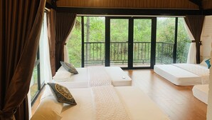 A spacious room with a large window, a balcony, and a bed with pillows.
