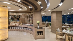 A modern hotel lobby with a curved reception desk, seating area, and a view of the city through large windows. - Solitaire Bangkok Sukhumvit 11 by Kingston Hotels (Bangkok)
