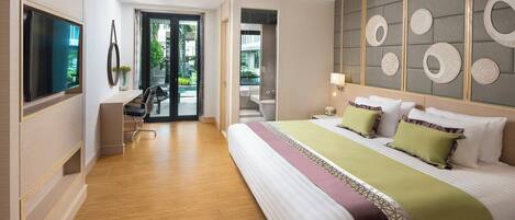 Quarto de hotel moderno com uma cama grande, escrivaninha, televisão e vista para o exterior.