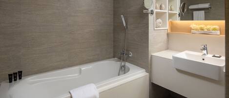 A modern bathroom with a bathtub, a sink, and a mirror.