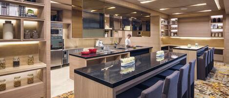 Una cocina moderna con electrodomésticos integrados, una isla central y taburetes de bar.