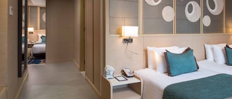 Una habitación de hotel con cama, mesita de noche, lámpara y una pared decorada con diseños circulares.