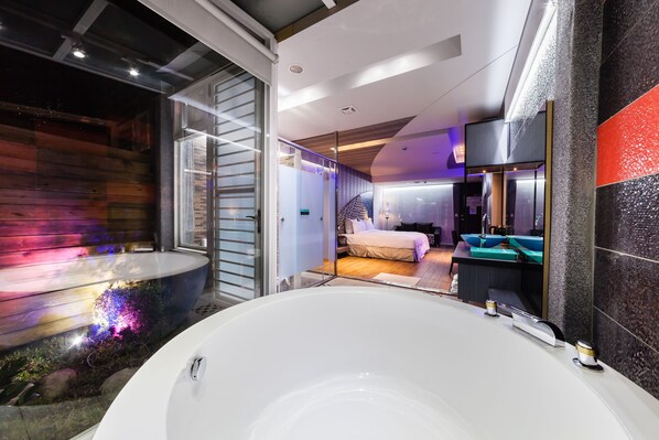 Standaard tweepersoonskamer | Badkamer | Een aparte badkuip en douche, een haardroger, pantoffels, handdoeken