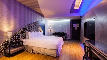 A modern bedroom with a large bed, a TV, and a desk.