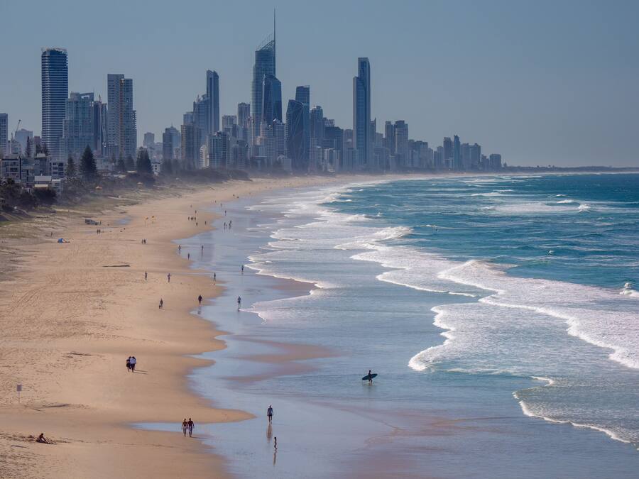 Una playa con un horizonte urbano al fondo.