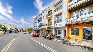 A street view with a hotel named "Hotel Changhong" on the right, featuring a balcony with potted plants. - Wei Yuan Hotel (Hengchun)