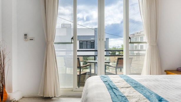 A bedroom with a large sliding glass door leading to an outdoor balcony. - Wei Yuan Hotel (Hengchun)