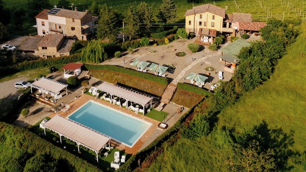 A large estate with multiple buildings, a swimming pool, and surrounding green fields. - Casale Serena 1912 (Fabro)