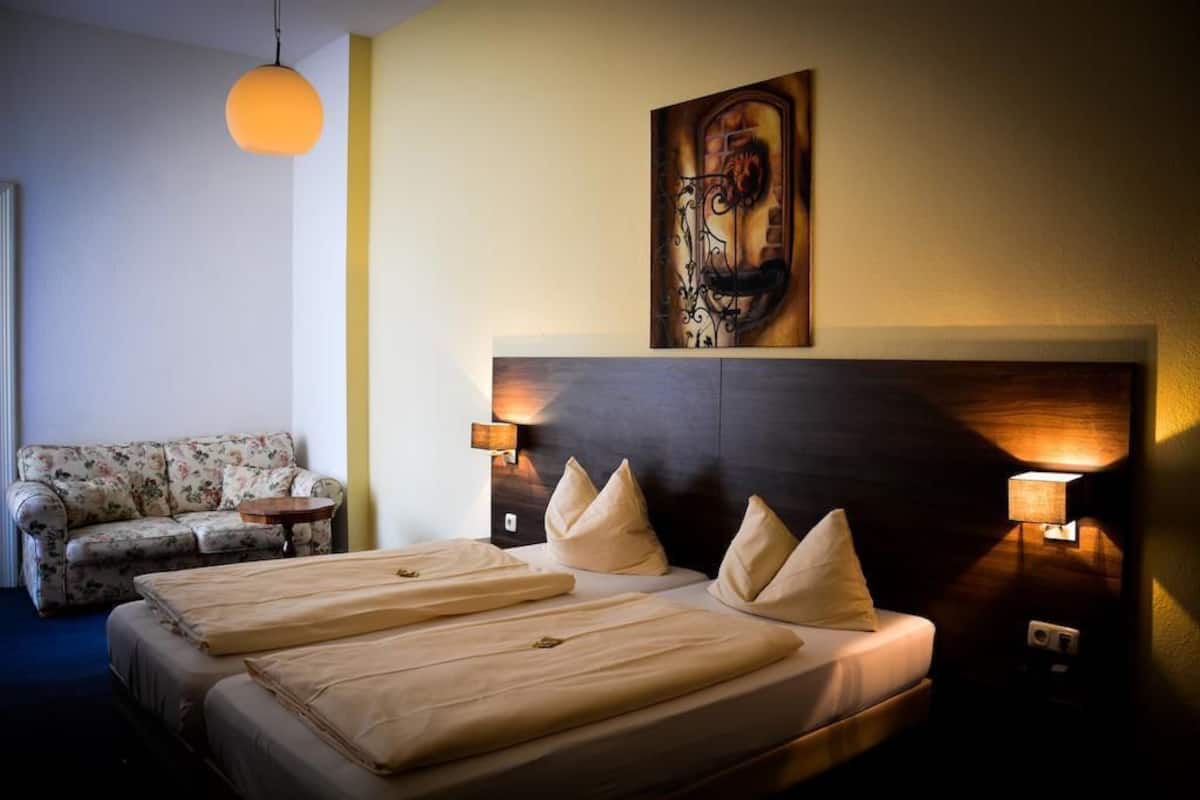 Habitació d'hotel amb un llit gran, un sofà i un quadre a la paret.
