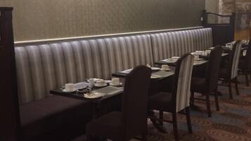 Un restaurante con asientos tipo cabina, mesas y sillas.
