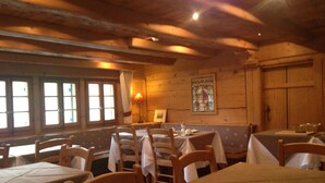 Un restaurante acogedor con paredes y mesas de madera preparadas para comer.