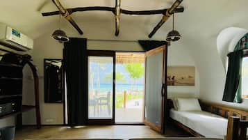 Una habitación con cama, escritorio y vista al mar.