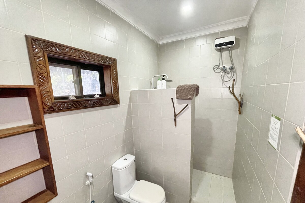 Un baño pequeño con inodoro, ducha y espejo.