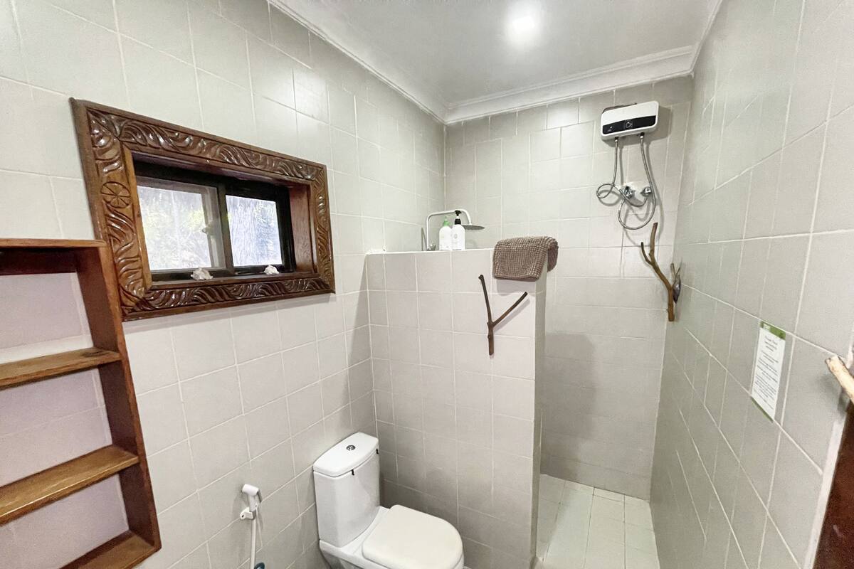 A bathroom with a toilet, a shower, and a sink.