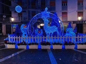 A decorative display with illuminated blue lights, including a circular design and reindeer figures, set against a building backdrop. - B&B villa Arechi (Salerno)
