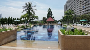 A swimming pool with lounge chairs and a small pavilion. - Jomtien Beach Condominium (Pattaya)
