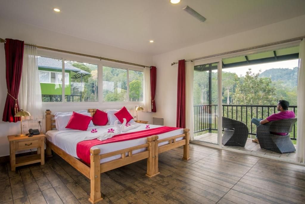 A bedroom with a wooden bed, a nightstand, a window with curtains, and a balcony with a chair.