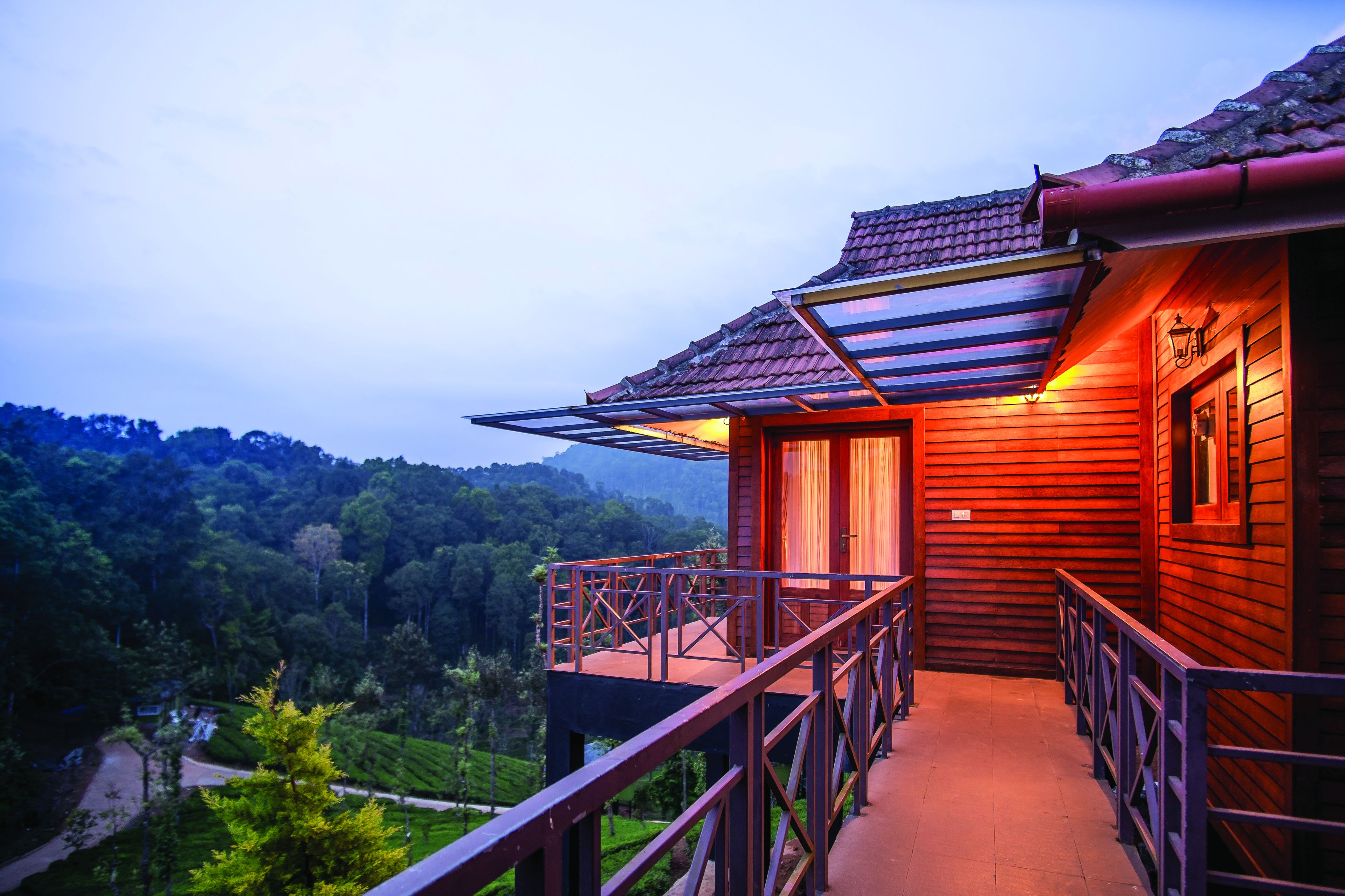 A wooden building with a balcony overlooking a lush valley.